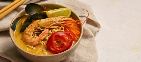 Bowl of tasty Thai soup on light background