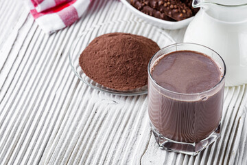 chocolate cocoa milk powder on a white wooden rustic background