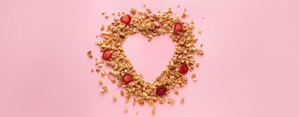 Heart made of tasty granola on pink background