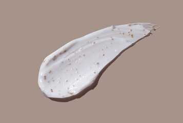 Scrub cream swatch smear smudge on brown color background.