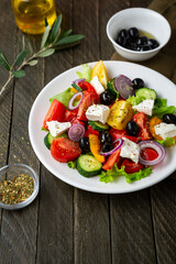  Fresh Greek salad o white plate mediterranean food on wooden background