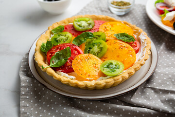 Close up of quiche with cheese and tomatoes on plate polka dots textile