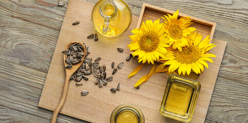 Fresh sunflower oil with seeds on wooden background