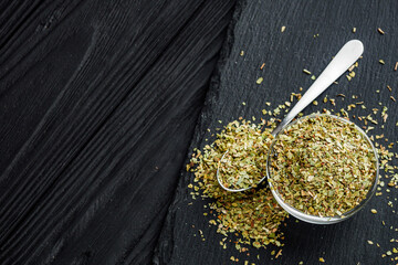 dried fragrant oregano marjoram on a black stone background