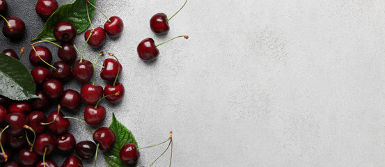 Bowl of tasty cherries on light background with space for text, top view