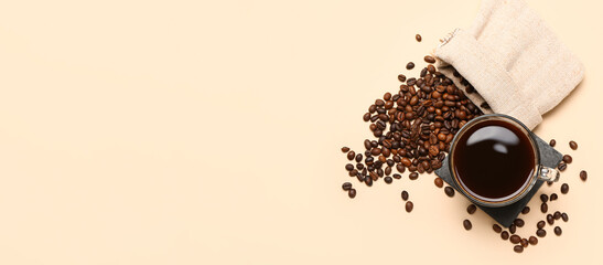 Cup of hot coffee and beans on beige background with space for text, top view
