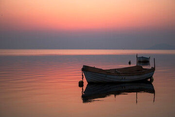 Horizontal photograph of a sunrise in the Mar Menor of Murcia, Spain, with fishing boats in the...