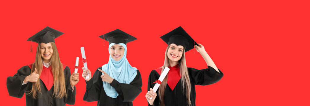 Female students in bachelor robes and with diplomas on red background with space for text