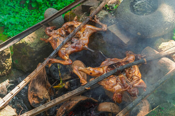 Traditionally smoky grilled chicken using wood and coconut skin, editable filter raw photo