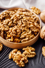 dried walnuts on a black rustic wooden background
