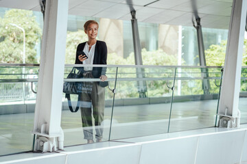 Happy Business Woman Using Mobile Phone While Standing At Footbridge In The Bangkok