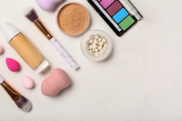 Set of different cosmetics and makeup accessories on light background