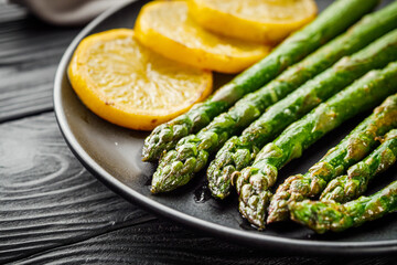 roasted green asparagus on a black wooden rustic background