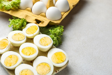 Plate with halves of boiled chicken eggs and lettuce on light background, closeup