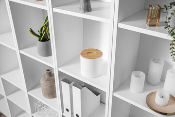 White shelving unit with folders and decor in room, closeup