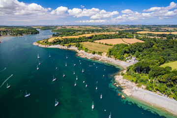 Obraz premium Aerial shot of Helford river, rural landscape, villages, beaches, water and boats. Cornwall UK