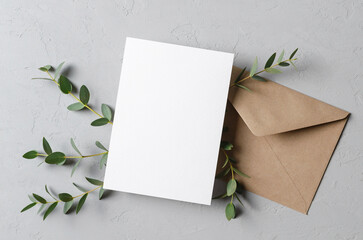 Blank invitation or greeting card mockup with envelope and eucalyptus plant decoration