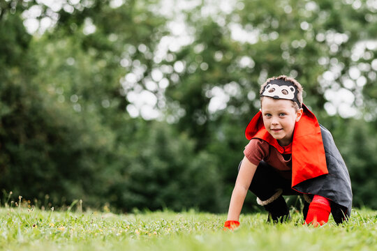 Little superhero playing on grass