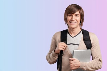 Male student with backpack on light background