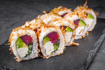 delicious sushi rolls on a black stone background