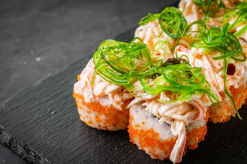 delicious sushi rolls on a black stone background