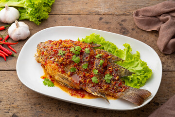 Three Flavoured Deep fried Fish,Fried fish with chili garlic and palm sugar,spicy sweet sauce in white plate (Pla Rad Prik)