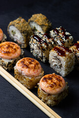 Rolls on a black background. Traditional Japanese food. Set of different types of rolls