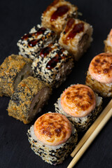 Rolls on a black background. Traditional Japanese food. Set of different types of rolls