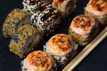 Rolls on a black background. Traditional Japanese food. Set of different types of rolls