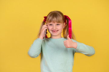 Little blond beautiful girl of 7 years , using a mobile phone