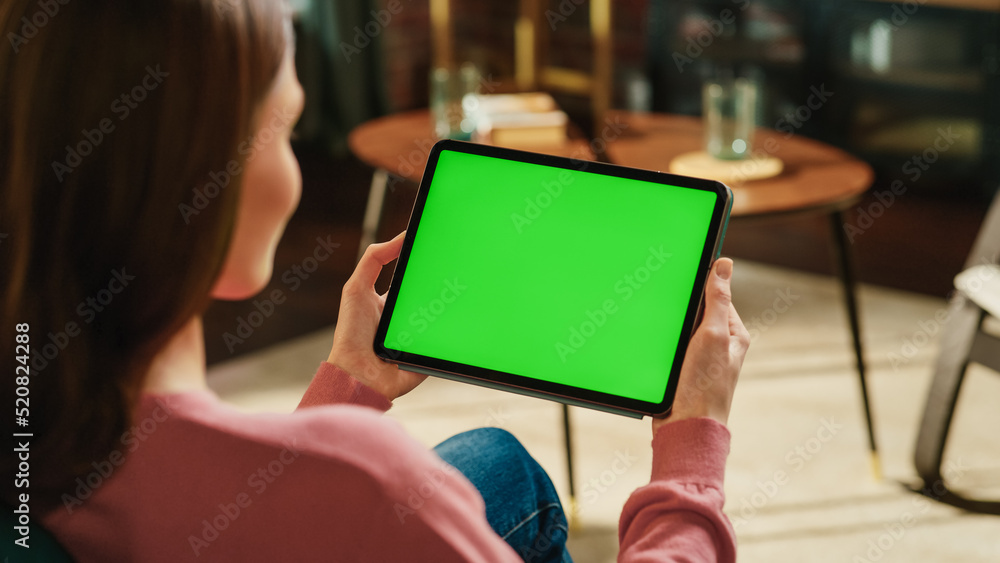 Poster Female Holding Tablet Computer with Green Screen Mock Up Display. Woman Relaxing at Home, Watching Videos and Reading Social Media Posts on Mobile Device. Close Up Over the Shoulder Photo.