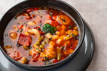 Minestrone Soup is a thick soup of Italian origin made with vegetables, often with the addition of pasta or rice.