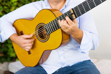 Close up portrait of a man playing guitar outdoors.