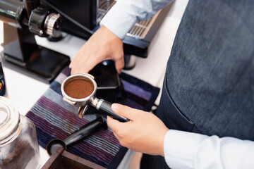 Barista hold portafilter with grind coffee bean making fresh coffee by coffee machine