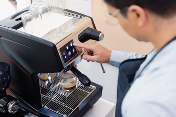 Barista using coffeemaker making fresh coffee in cafe