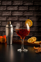 glass with juice and orange drink with shaker and natural oranges and liquid flying through the air forming a splash on cocktail bar