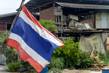 The national flag of Thailand flutters on the street on the outskirts of the city.