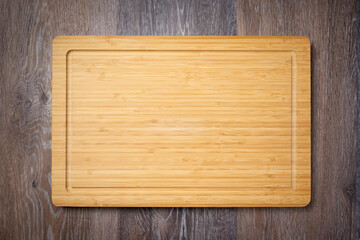 Wooden chopping board. Kitchen cutting board on wooden table, top view