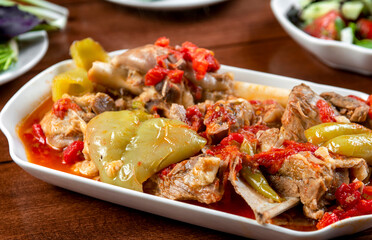 Khashlama is popular Armenian dish, which is prepared from beef with vegetables. Khashlama in the plate. stewed lamb on the bone with vegetables on wooden desk