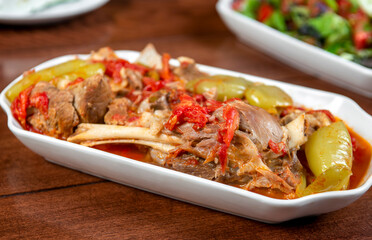 stewed lamb on the bone with vegetables on wooden desk