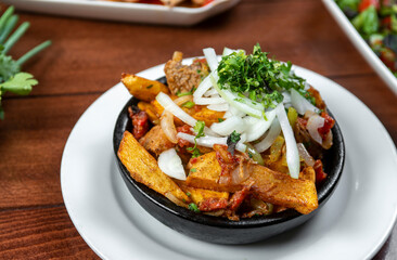 Beef stew with potatoes, carrots and herbs on black background with copy
