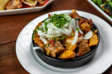 Beef stew with potatoes, carrots and herbs on black background with copy