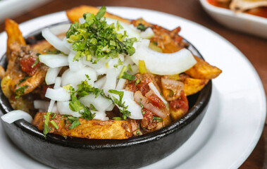Beef stew with potatoes, carrots and herbs on black background with copy