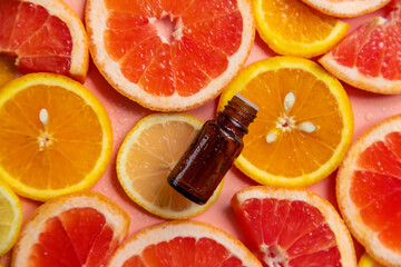 Fototapeta na wymiar Essential oil of orange on a yellow background. Selective focus.