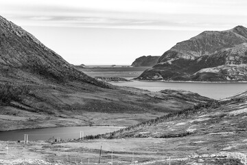 Fototapeta na wymiar beautiful black and white panorama of a lake, a fjord and Norwegian mountains