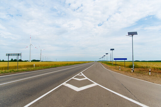 A deserted road. Solar panels. Wind generators. Ecology.