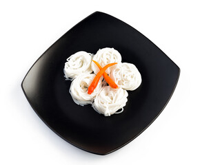 Rice noodle in black ceramic dish isolated on a white background.