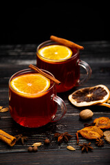 Fruity mulled wine on a wooden background with spices.