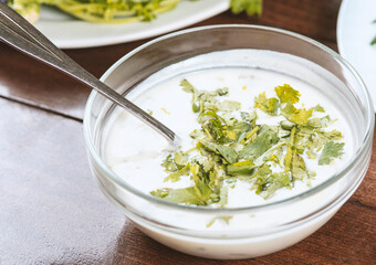 yogurt soup with herbs in a plate on a wooden table.spas