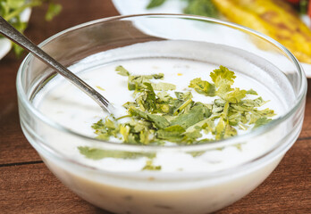 yogurt soup with herbs in a plate on a wooden table.spas